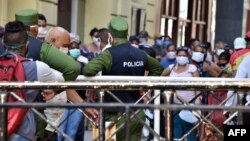 Policías controlando la población en una cola para conseguir alimentos